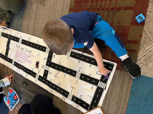 an overhead view of a young boy playing on a word activity